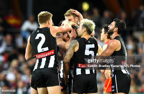 Jarryd Blair of the Collingwood Magpies celebrates with team mates after kicking a goal during the round 17 AFL match between the Gold Coast Suns and...