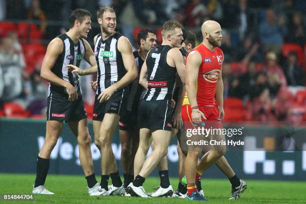 Ben Reid of the Magpies celebrates a goal with team mates during the round 17 AFL match between the Gold Coast Suns and the Collingwood Magpies at...