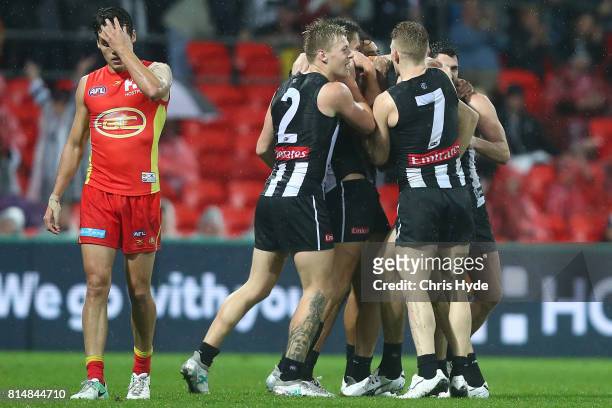 Ben Reid of the Magpies celebrates a goal with team mates during the round 17 AFL match between the Gold Coast Suns and the Collingwood Magpies at...