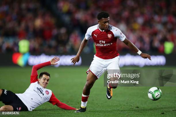 Alex Iwobi of Arsenal is challenged by Steve Lustica of the Wanderers during the match between the Western Sydney Wanderers and Arsenal FC at ANZ...