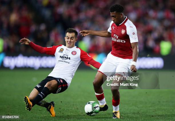 Alex Iwobi of Arsenal is challenged by Steve Lustica of the Wanderers during the match between the Western Sydney Wanderers and Arsenal FC at ANZ...