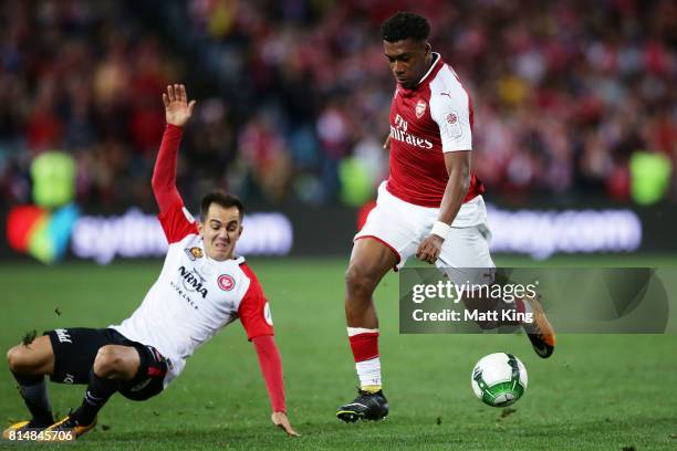 Alex Iwobi of Arsenal is challenged by Steve Lustica of the Wanderers during the match between the Western Sydney Wanderers and Arsenal FC at ANZ...