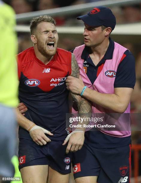 Dean Kent of the Demons leaves the field with an injury during the round 17 AFL match between the Melbourne Demons and the Adelaide Crows at TIO...