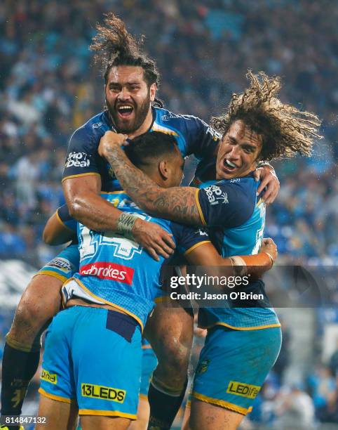 Pat Politoni celebrates a try with Kevin Proctor and Konrad Hurrell during the round 19 NRL match between the Gold Coast Titans and the Cronulla...