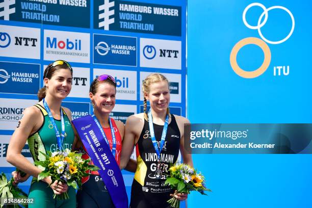 Ashleigh Gentle of Australia , Flora Duffy of Bermuda and Lena Lindemann of Germany celebrate the sprint distance on stage at the Hamburg Wasser ITU...