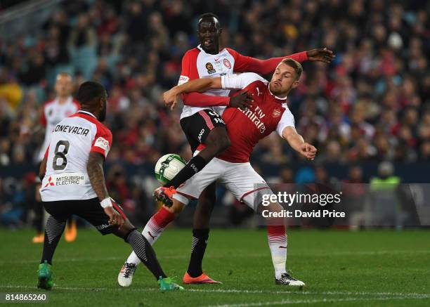 Aaron Ramsey of Arsenal is challenged by Abraham Majok and Roly Bonevacia of Western Wanderers during the match between the Western Sydney Wanderers...