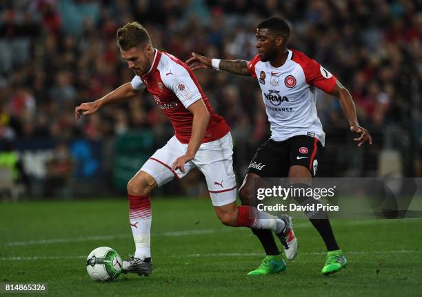 Aaron Ramsey of Arsenal takes on Roly Bonevacia of Western Wanderers during the match between the Western Sydney Wanderers and Arsenal FC at ANZ...