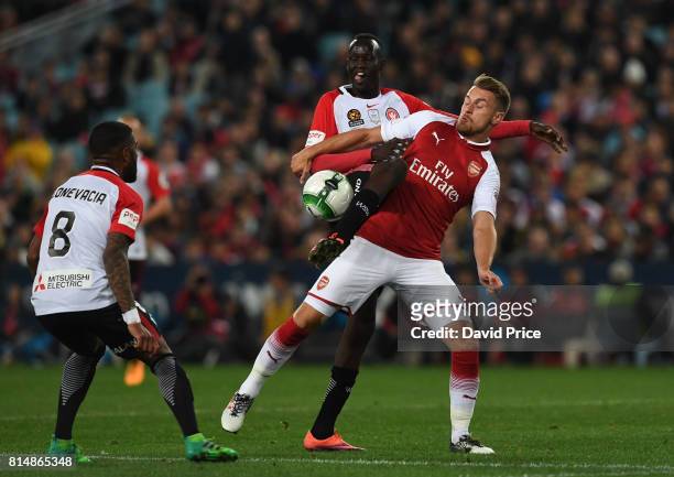 Aaron Ramsey of Arsenal is challenged by Abraham Majok and Roly Bonevacia of Western Wanderers during the match between the Western Sydney Wanderers...