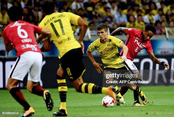 Dortmund's forward Christian Pulisic dribbles past Urawa's forward Rafael Da Silva during their friendly football match between Japan's Urawa Reds...