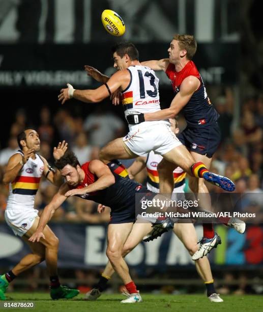 Michael Hibberd of the Demons, Taylor Walker of the Crows and Oscar McDonald of the Demons compete for the ball during the 2017 AFL round 17 match...