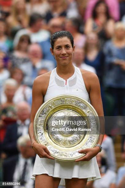 Garbine Muguruza of Spain celebrates victory with the trophy after the Ladies Singles final against Venus Williams of The United States on day twelve...