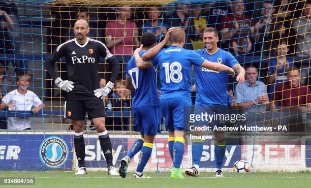 Watford goalkeeper Heurelho Gomes looks dejected as AFC Wimbledon's Cody McDonald celebrates with his team mates after he scores his and their side's...