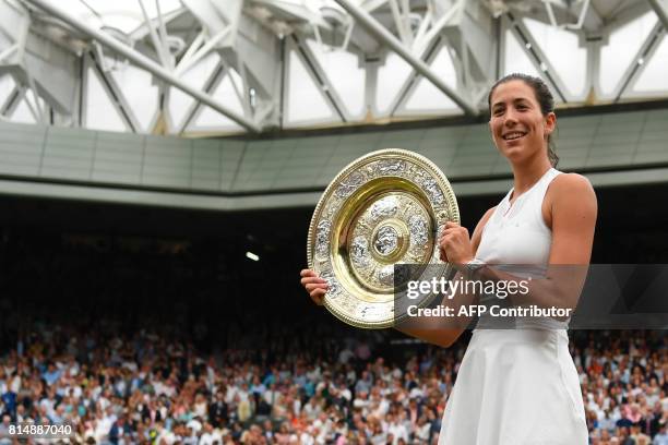 Spain's Garbine Muguruza holds up The Venus Rosewater Dish as she celebrates beating US player Venus Williams to win the women's singles final on the...