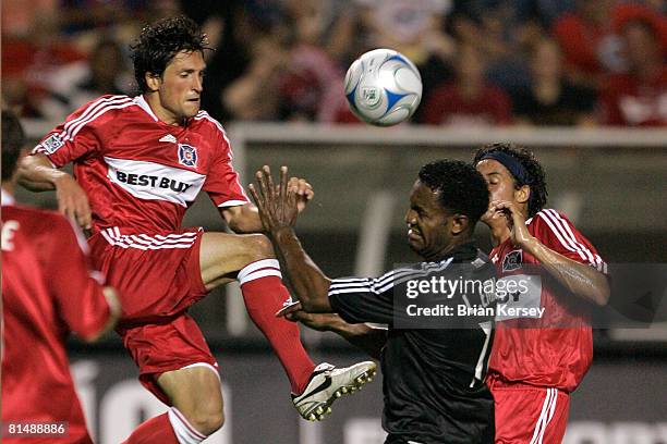 John Thorrington and Calen Carr of the Chicago Fire try to move the ball pase Luciano Emilio of D.C. United during the second half at Toyota Park on...