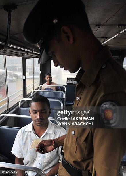 Sri Lankan policeman makes a security check of the passengers aboard a bus in Maharagama suburb of Colombo on June 7, 2008. Sri Lankans are living on...
