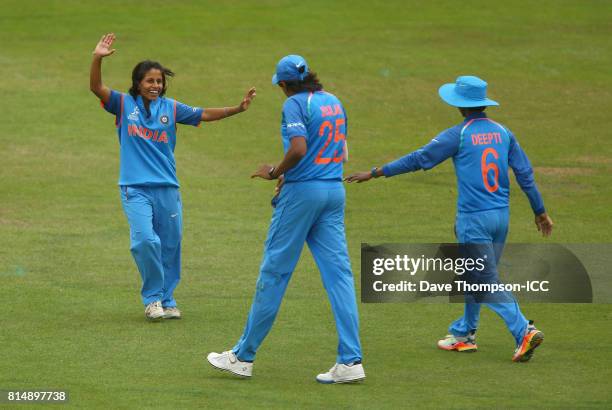 Poonam Yadav of India celebrates with Jhulan Goswami of India and Deepti Sharma of India after taking the wicket of Maddy Green of New Zealand during...