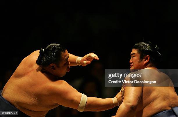 Kotomitsuki absorbs a frontal push out or "oshitaoshi" from Chiyotaikai during the second match of the fourth round during the 2008 Grand Sumo...