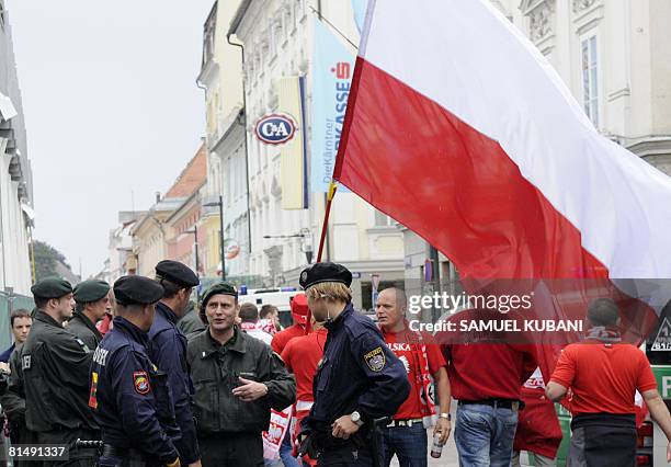 German riot police stand near Polish football fans celebratring in a street of Klagenfurt on June 8 a few hours before the beginning of the Euro 2008...