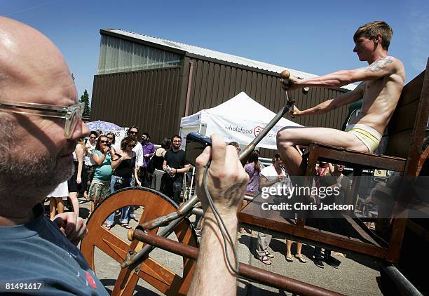 Man takes photographs of a contraption powered by men in underpants during the vauxhall Art Car Boot fair in the Old Truman Brewery on June 8, 2008...