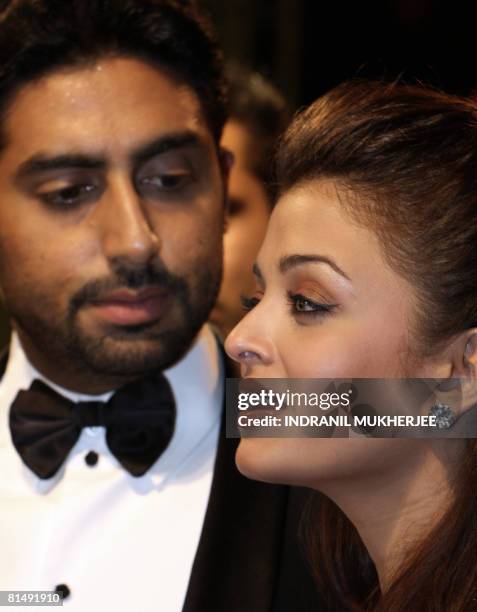 Indian actor Abhishek Bachchan watches his actor-wife Aishwarya Rai-Bachchan speak to the media on arriving at the International Indian Film Academy...