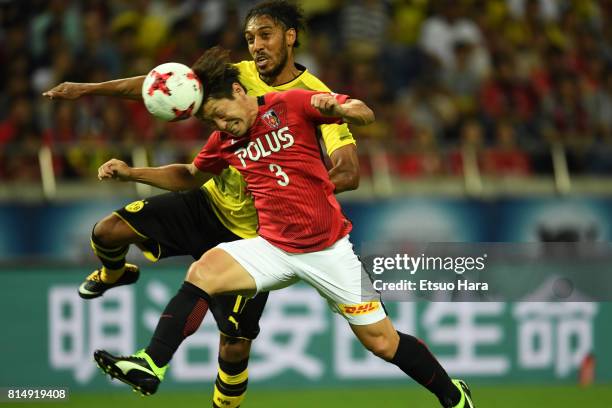 Pierre-Emerick Aubameyang of Burussia Dortmund and Tomoya Ugajin of Urawa Red Diamonds compete for the ball during the preseason friendly match...