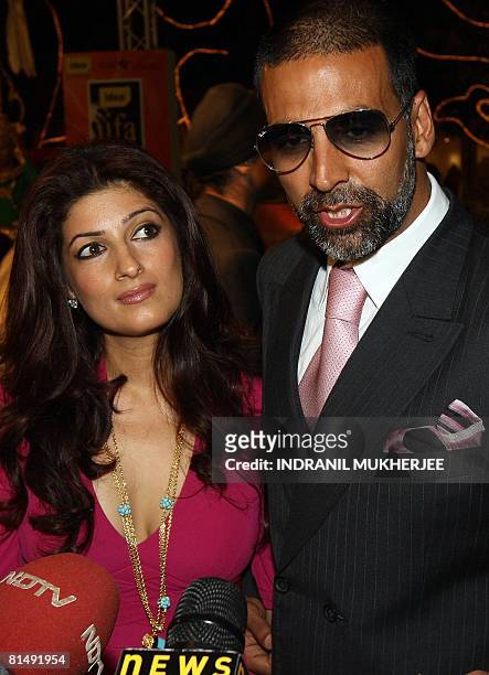 Indian actor Akshay Kumar speaks to the media as wife Twinkle Khanna watches on after they arrived for the International Indian Film Academy Awards...