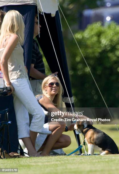 Chelsy Davy among friends strokes a beagle puppy dog while watching Prince Harry at Cirencester Park Polo Club in a charity polo match raising money...