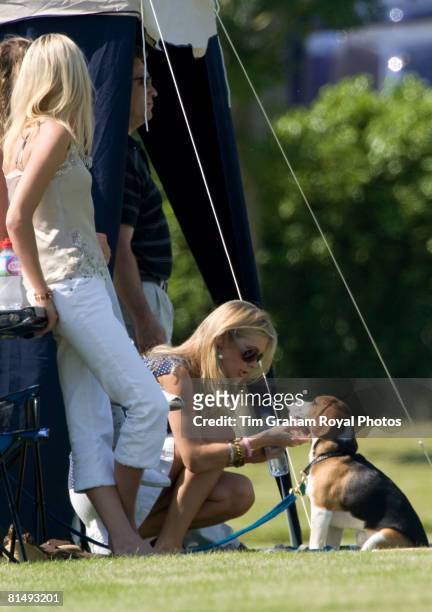 Chelsy Davy among friends strokes a beagle puppy dog while watching Prince Harry at Cirencester Park Polo Club in a charity polo match raising money...