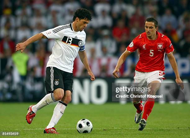 Michael Ballack of Germany looks to pass under pressure from Dariusz Dudka of Poland during the UEFA EURO 2008 Group B match between Germany and...