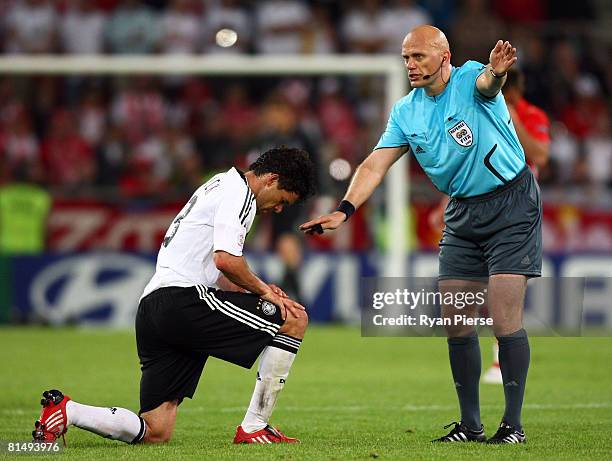 Michael Ballack of Germany gets to his feet as referee Tom Henning Ovrebo awards a free kick during the UEFA EURO 2008 Group B match between Germany...