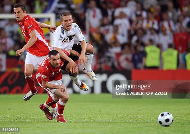 Polish midfielder Dariusz Dudka andPolish defender Marcin Wasilewski vie with German forward Lukas Podolski during their Euro 2008 Championships...
