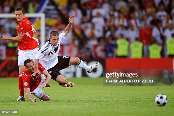 Polish midfielder Dariusz Dudka and Polish defender Marcin Wasilewski vie with German forward Lukas Podolski during their Euro 2008 Championships...