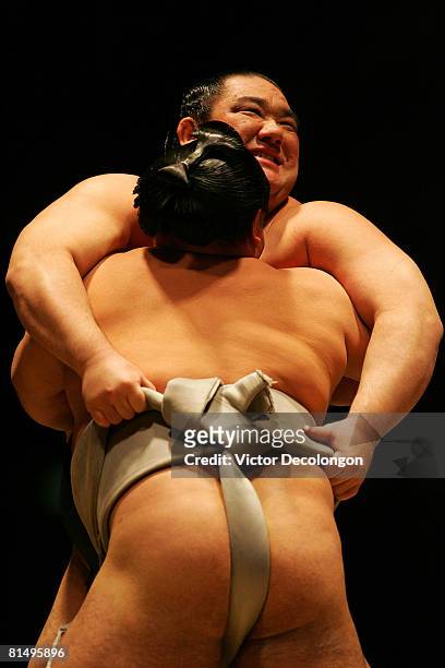 Wakanosato grabs the belt of Kakizoe en route to winning the match with a backward pivot throw or "ucchari" during the 2008 Grand Sumo Tournament at...