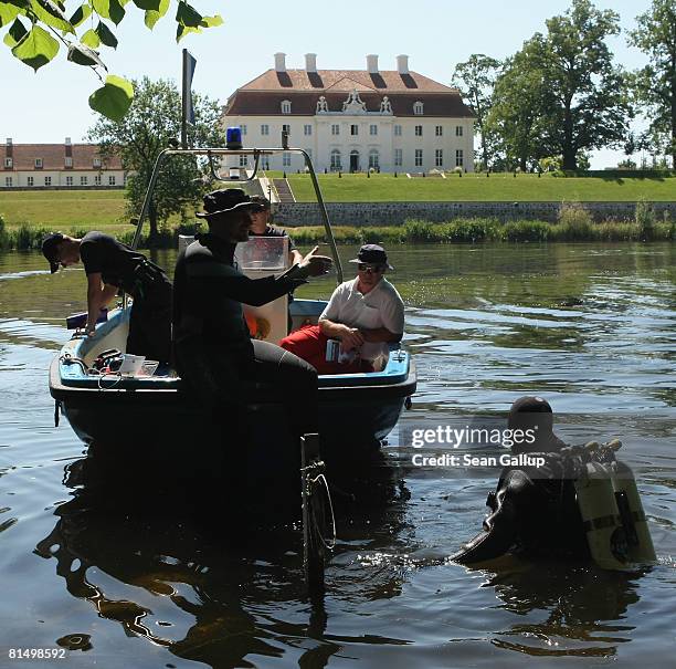 Police divers enter the lake behind Schloss Meseberg Palace, the guest house of the German government, during a security check a day ahead of the...