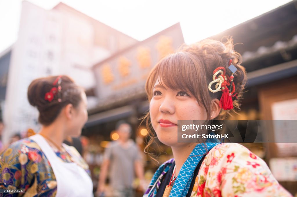 Young women in Japanese matsuri outfit standing on street