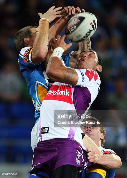 Ben Jeffery of the Titans and Joseph Tomane of the Storm compete for the ball during the round 13 NRL match between the Gold Coast Titans and the...