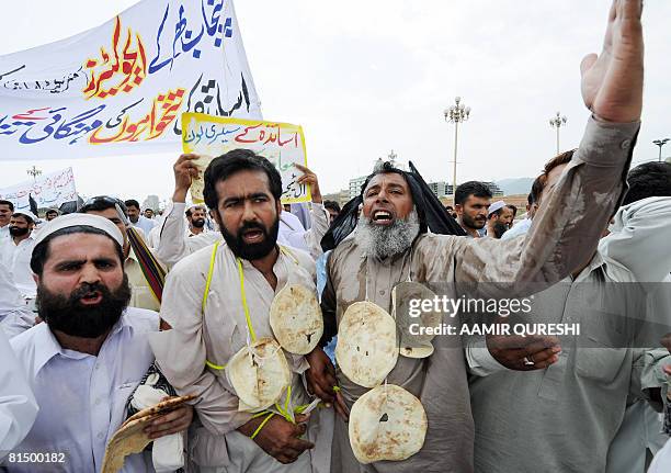 Pakistani government schools teachers hang breads as they shout slogans during a demonstration in front of the Parliament House in Islamabad on June...