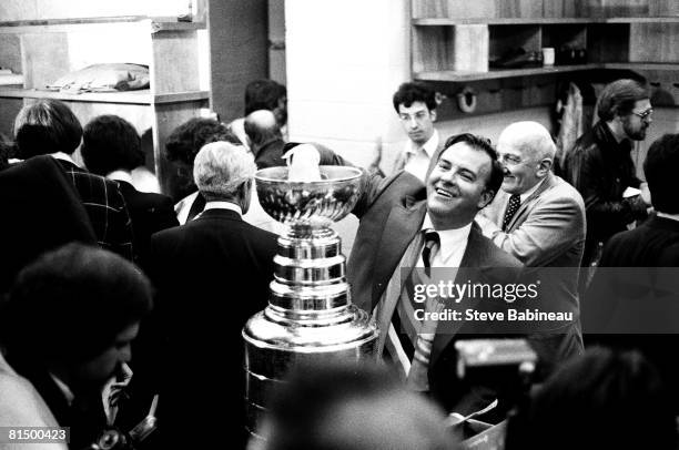 Scotty Bowman coach of the Montreal Canadiens celebrates winning the Stanley Cup against the Boston Bruins at Boston Garden .