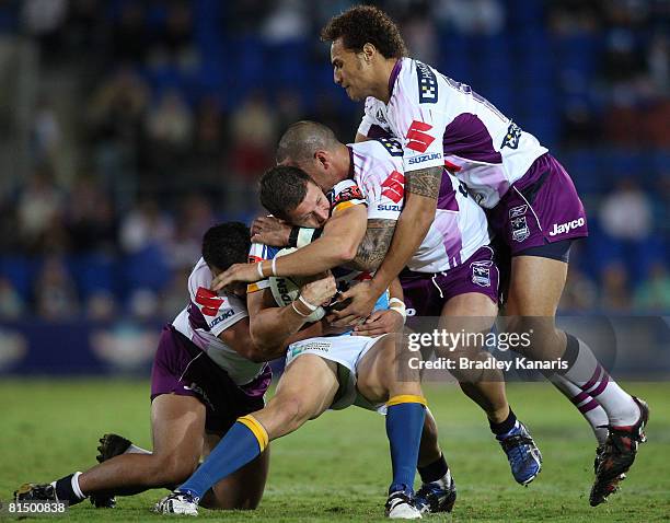 Jordan Atkins of the Titans is tackled during the round 13 NRL match between the Gold Coast Titans and the Melbourne Storm at Skilled Stadium on June...