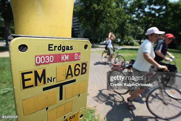 Cyclists stand next to a sign that refers to a gas line on June 9, 2008 in Frankfurt, Germany. The German Department of Environment expects a rise of...