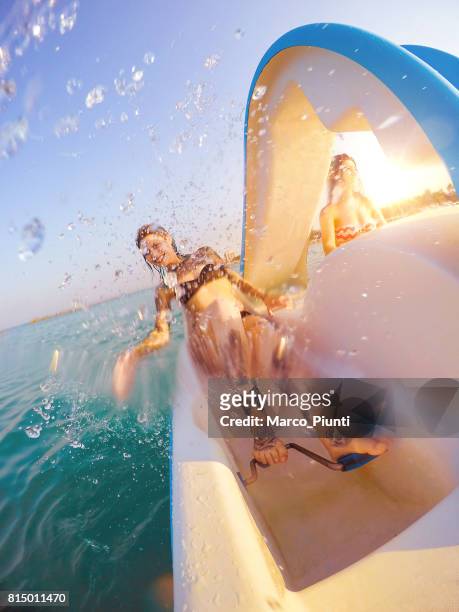 deux jeunes femmes reposantes sur le bateau à pédales - pedal boat photos et images de collection