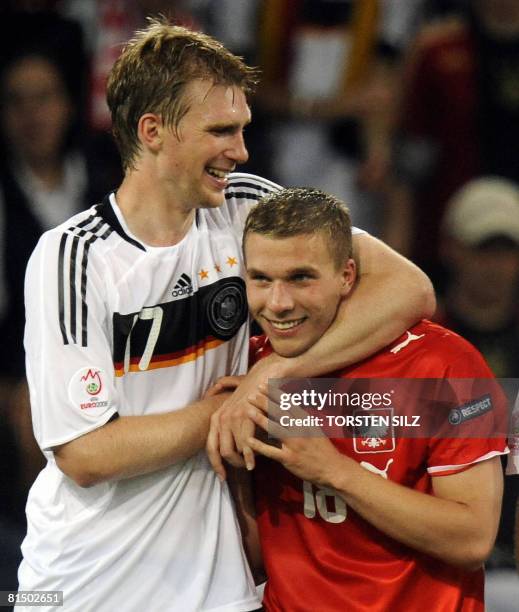 German forward Lukas Podolski, wearing the jersey of Polish midfielder Mariusz Lewandowski and teammate defender Per Mertesacker celebrate at the end...