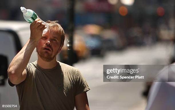 Man tries to cool himself with a bottle of water during the first heat wave of the year June 9, 2008 in New York City. According to the National...
