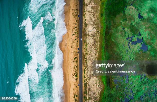 golven van de zee, strand en weg - cliff texture stockfoto's en -beelden