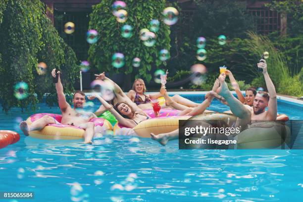 vrienden tijdens een zomerdag - poolparty stockfoto's en -beelden