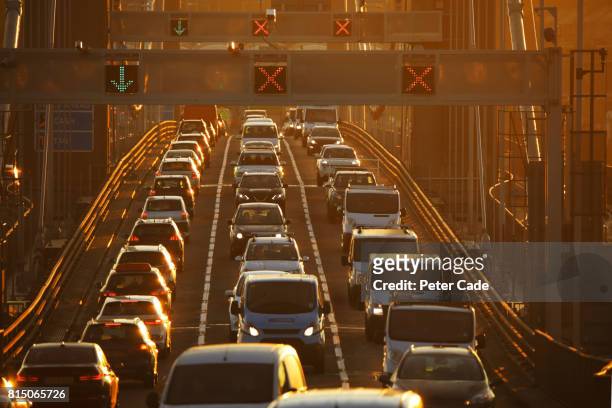 heavy traffic on bridge at sunset - luftverschmutzung stock-fotos und bilder