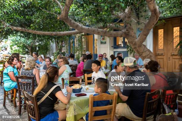 people dinining in restaurants at mpnastiraki square, athens, greece - plaka greek cafe stock pictures, royalty-free photos & images