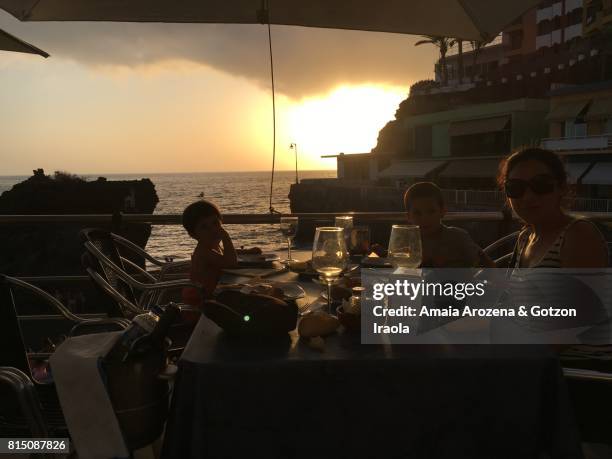 mother and children dining in puerto naos at sunset. la palma island, canary islands, spain - puerto naos stock pictures, royalty-free photos & images