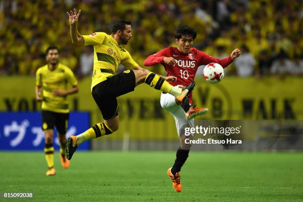 Gonzalo Castro of Burussia Dortmund and Yosuke Kashiwagi of Urawa Red Diamonds compete for the ball during the preseason friendly match between Urawa...