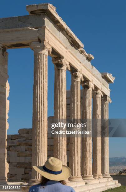 hatted tourist in front of old athena temple, acropolis athens,greece - ionic stock pictures, royalty-free photos & images